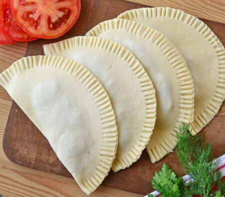 Tschebureki mit Schweinefleisch, Käse und Tomaten